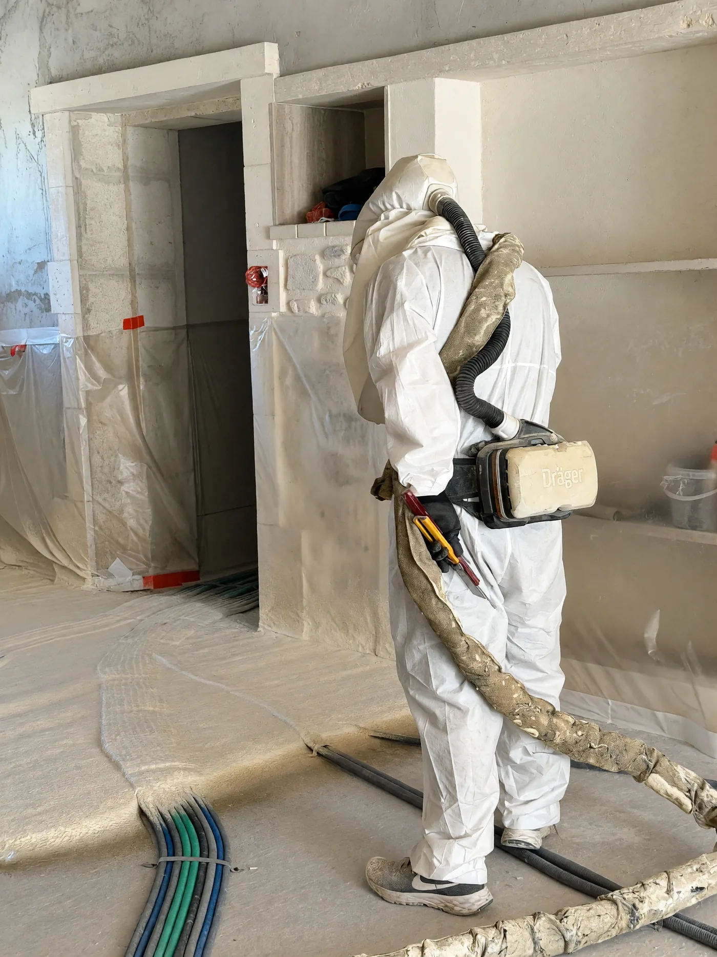 Chantier bâché, gaines au sol, avant projection